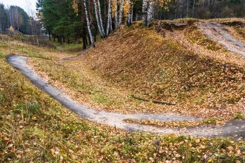 A steep hillside and a winding path on the edge of an autumn forest. Stock Photos
