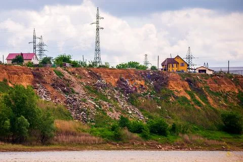 A steep hillside sloping down to the river littered with trash thrown by loca Stock Photos