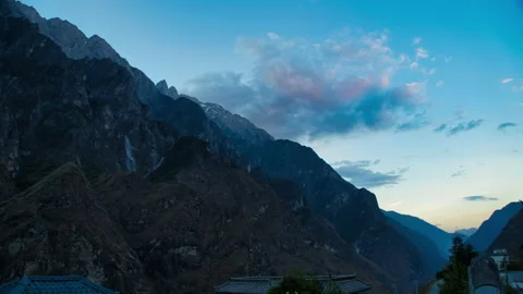 Steep mountain range during the period from day to night and moving clouds Stock Footage 166018330