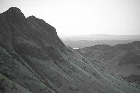 Steep Mountain Ridge Casting Shadows Over Remote Valleys Stock Photos
