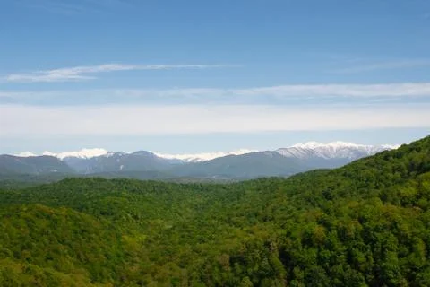 Steep mountains against green forest Stock Photos