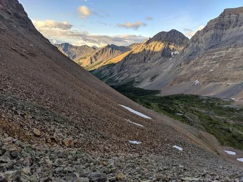 Steep mountains between a valley during sunrise Stock Photos