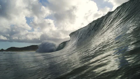 Steep Ocean Wave Breaking Into White Spray Beneath Bright Clouds Stock Footage 344374707