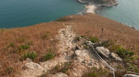 Steep path lie downhill, sea shore and small island seen below Video stock 57329487
