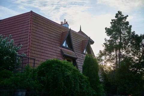 Steep red tiled roof with triangular dormer windows on a residential house fr Stock Photos