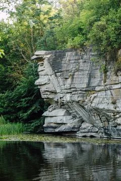 Steep Rocky Canyon Cliffs with Trees and Water Reflection Stock Photos