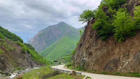 Steep rocky cliffs with green forest and distant mountain view Stock Footage 310247022