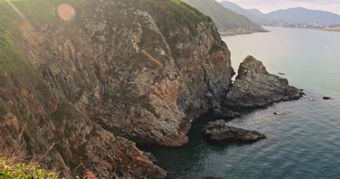 Steep Rocky Cliffs Overlooking Calm Sea at Golden Hour Stock-Footage 330512944