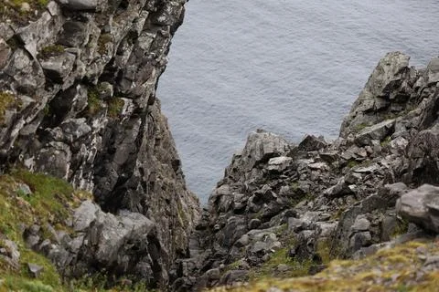 Steep rocky crevice looking down towards the cold arctic ocean at Nordkapp, N Stock Photos