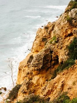 Steep, rugged cliffs overlooking the ocean, with textured rock formations and Stock Photos