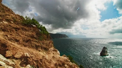 The steep slope of an orange-yellow mountain with stones and small plants Stock Footage 217727587