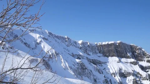 Steep slopes of the Caucasus covered with snow. Clear blue sky over rocky 스톡 동영상 79091673