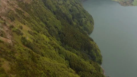 Steep slopes of volcano caldera covered withh green trees. Mountain above lake Stock Footage 121269998