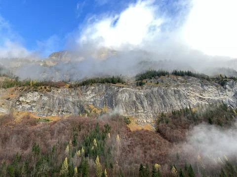 Steep stone cliffs and vertical rocks above the alpine Taminatal valley Stock Photos