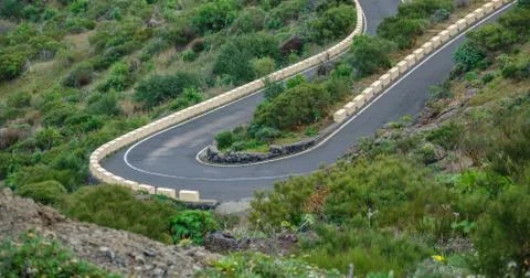 Steep u-shape curved mountain road in the middle of the bush Stock Photos