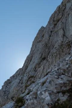 Steep vertical wall in Julian Alps with two visible climbers rising to top Stock Photos