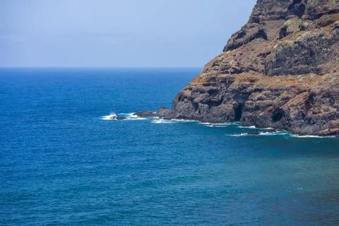 Steep volcanic cliff dropping into deep blue Atlantic Ocean at Punta del Fron Фото