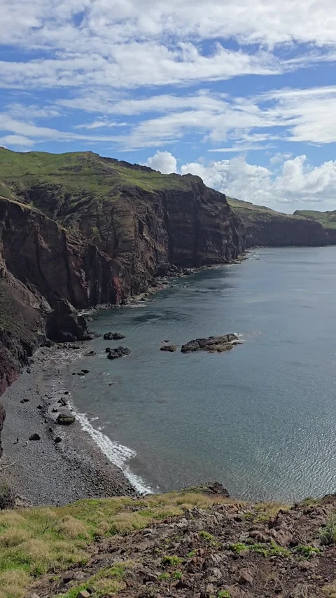 Steep volcanic cliffs drop to the rocky shores of Baía d’Abra, Ponta de São Lour Stock Footage 310025137
