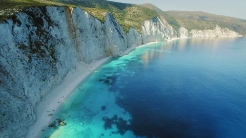 Steep white cliffs and deserted beach with clear blue water in Cephalonia Greece Stock Footage 310520968