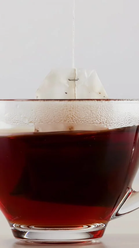 Steeping and Brewing Tea Bag in Clear Glass Mug Stock Footage 346345629