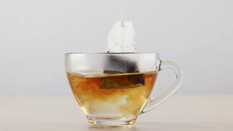 Steeping Tea Bag in Glass Cup with Hot Water Stock Footage 345015628