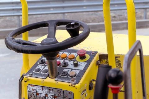 Steering wheel and control panel of road roller compactor. Foto stock