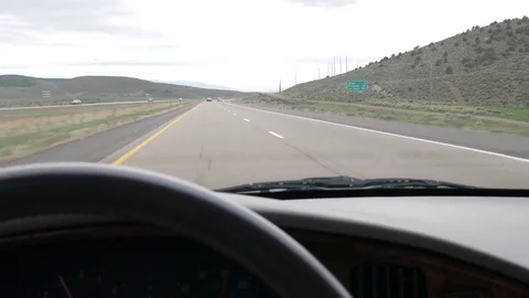 A steering wheel and dashboard in a car driving fast on a highway Stock Footage 75770096
