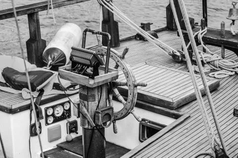 Steering wheel and deck of the old boat Stock Photos