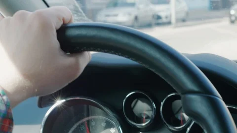 Steering wheel and hand during car driving on street, houses Stock Footage 105970746
