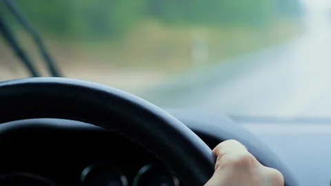 Steering wheel during car driving, rain, passing automobile Stock Footage 113682578
