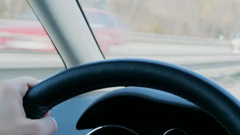 Steering wheel with hand during car driving on day highway Stock Footage 105968333