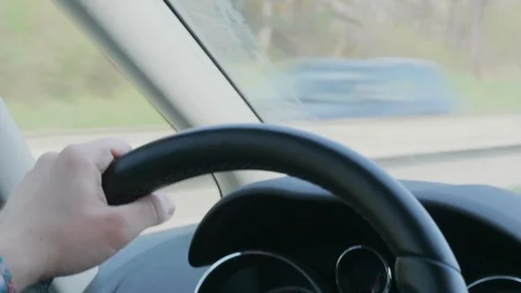 Steering wheel with hands during car driving on day highway Stock Footage 105946858