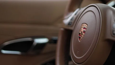 Steering wheel with Porsche logo inside salon. Interior of sport car Stock Footage 323650508