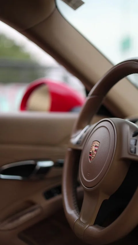 Steering wheel with Porsche logo. Interior of sport car Stock Footage 332573579