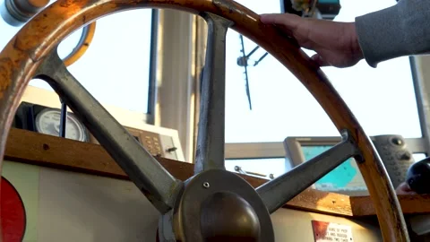 Steering wheel of vessel. Hand turns wooden wheel of boat. Stock Footage 233808917