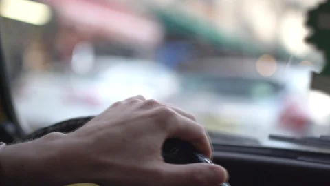 Steering wheel of a vintage car while man hand driving in city traffic Stock Footage 99101595