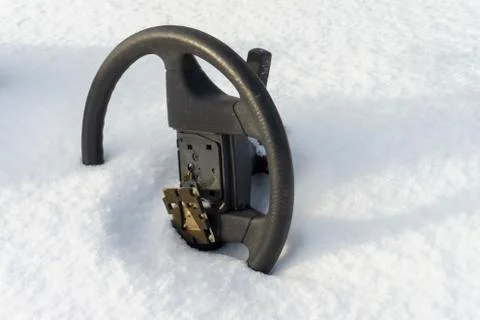 Steering wheel without airbag half buried in snow Stock Photos