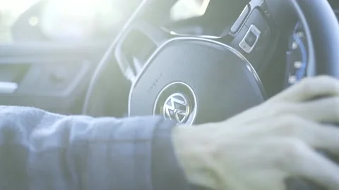 Steeringwheel with hands turning right with sun flares coming through window Stock Footage 171115928