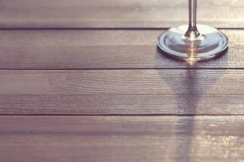 Stem of wine glass casting shadow on wooden table, copy space Stock Photos
