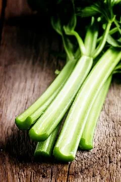 Stems of fresh celery with leaves on the table, vintage wooden background, .. Stock Photos