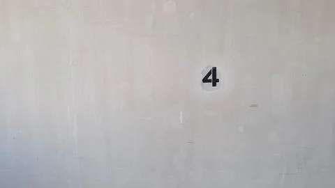 Stenciled number four painted on a plain wall Stock Photos