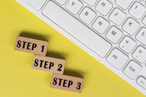 Step 1, 2 and 3 text on wooden blocks with keyboard. Stock Photos