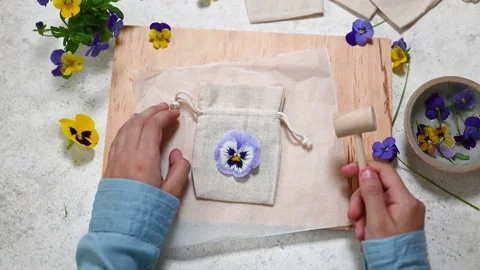 Step 1. Top view of workplace with cloth bags, pansy flowers, wooden hammer Stock Footage 280359692