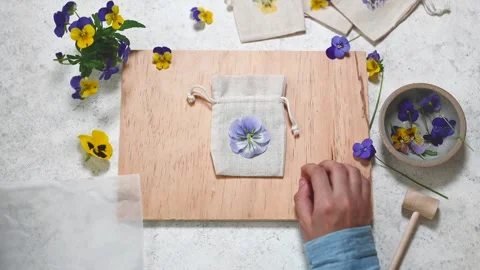 Step 2. Child places the flowers on the fabric bag and covers a flower Stock Footage 280359701