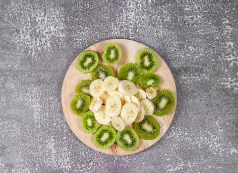 Step 4. Slicing fruit for smoothies. On a cutting board are sliced banana Stock-Fotos