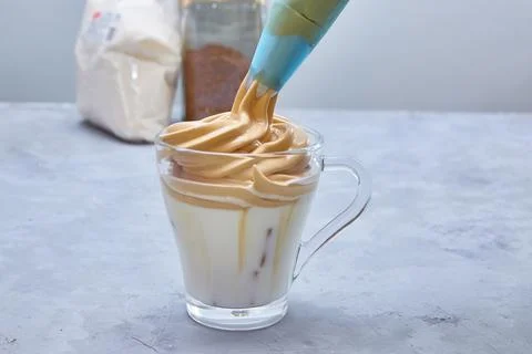 Step 7. Dalgona Coffee. Step by step cooking. Put whipped foam on top of milk Stock Photos
