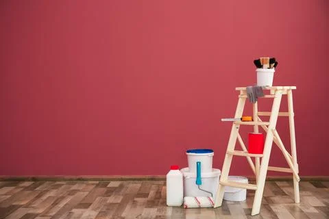 Step ladder and decorator's tools near color wall Stock Photos