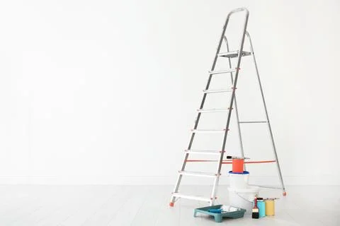 Step ladder and decorator's tools in light room Stock Photos