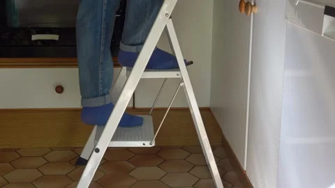 Step ladder for climbing to height in a kitchen setting Video stock 290238053