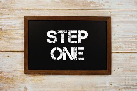 Step One text with gift box present and alarm clock on black background Stock Photos